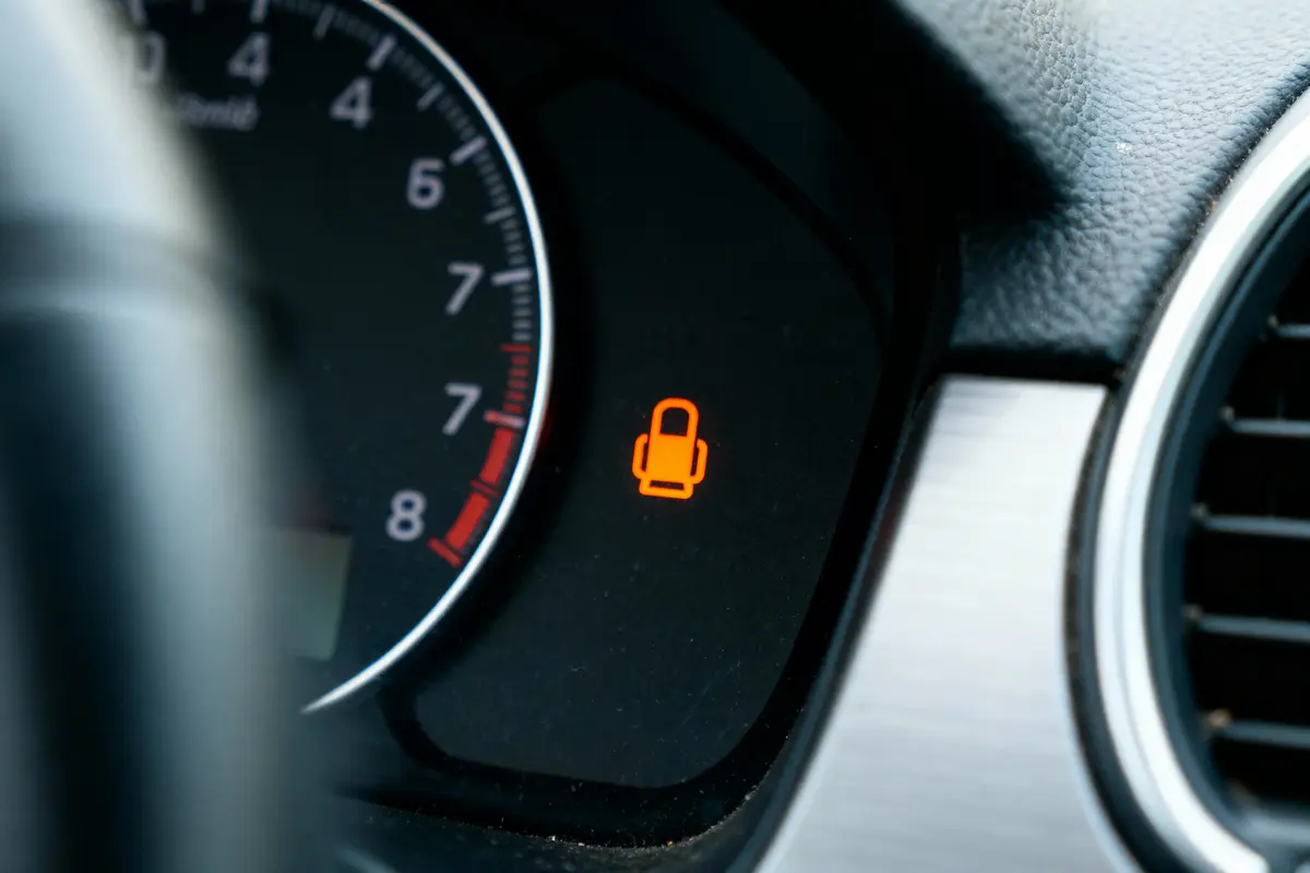 Voyant de sécurité ceinture de voiture allumé sur tableau de bord près d'un compteur de vitesse.