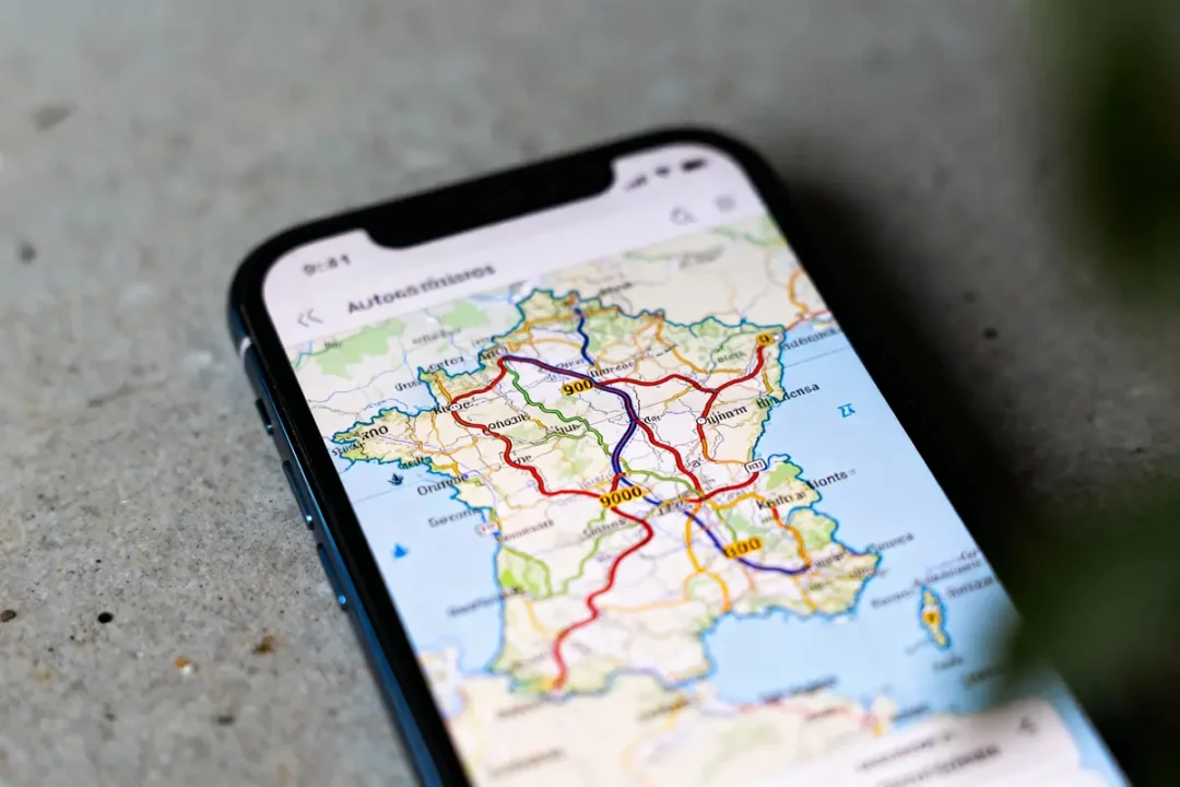 Carte routière de France affichée sur un smartphone posé sur une surface grise.
