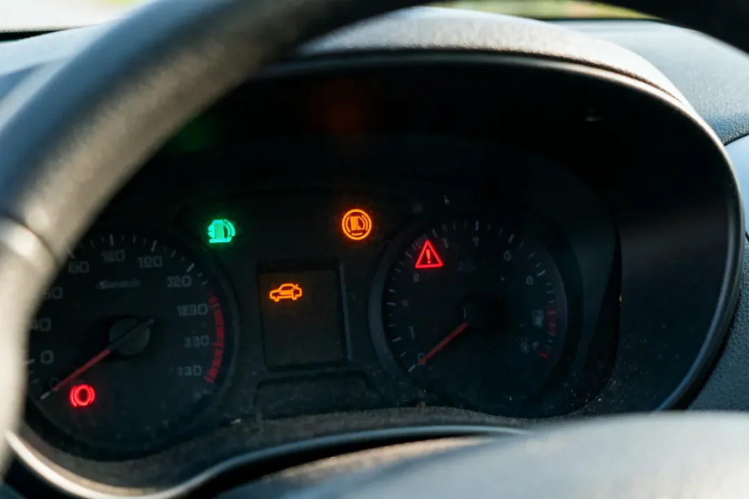 Tableau de bord de voiture avec voyants lumineux allumés, dont feux, avertissements et indicateurs d'entretien.