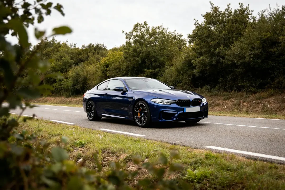 Voiture sportive Linea R bleue sur route bordée d'arbres.