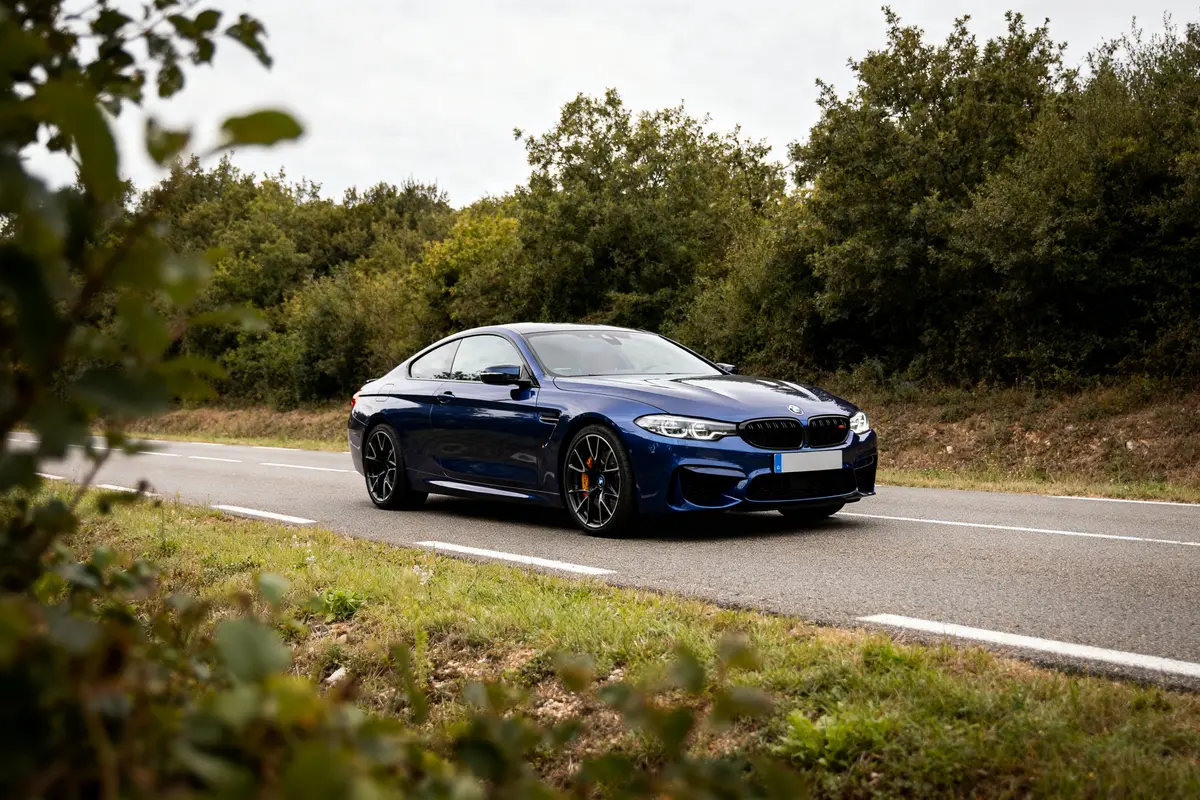 Voiture sportive Linea R bleue sur route bordée d'arbres.