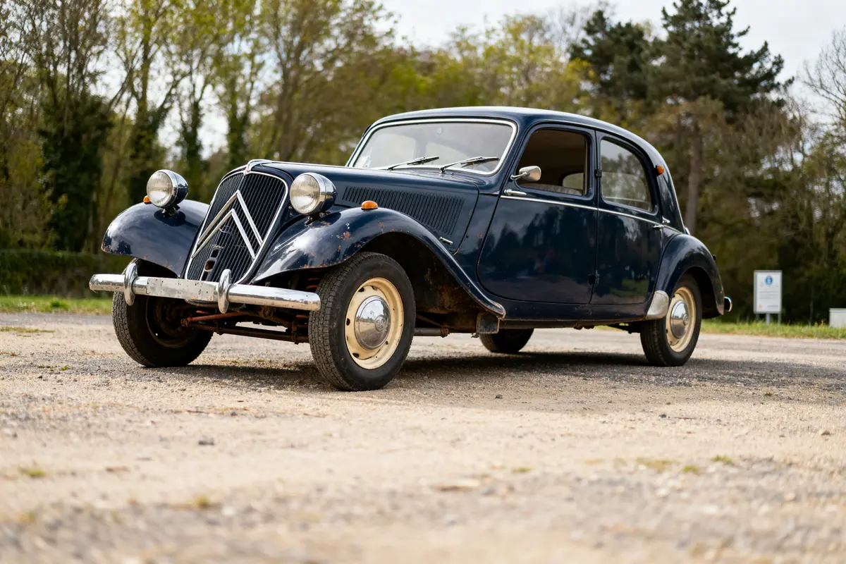 Citroën Traction Avant noire en extérieur sur un chemin gravillonné avec des arbres en arrière-plan