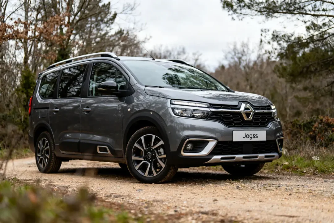 Véhicule gris Dacia Jogger stationné sur un chemin de terre en forêt