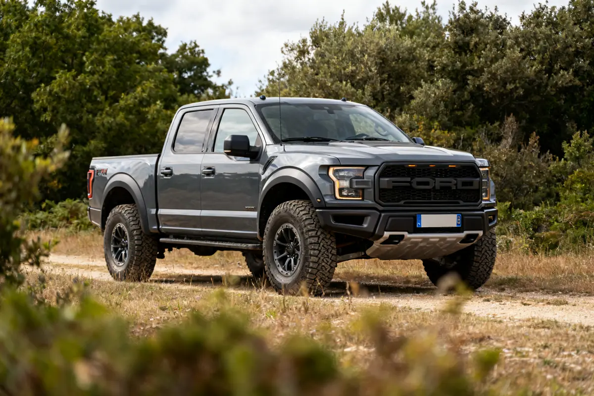 Pick-up Ford Raptor 4 door gris sur chemin forestier en pleine nature