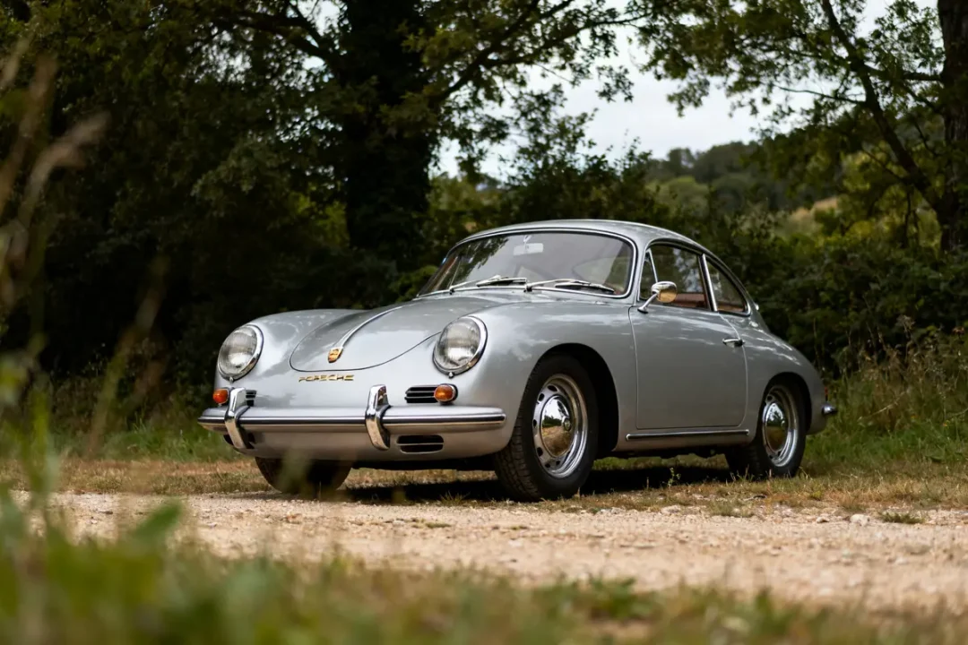Voiture sportive classique Porsche 356 grise stationnée sur un chemin en pleine nature