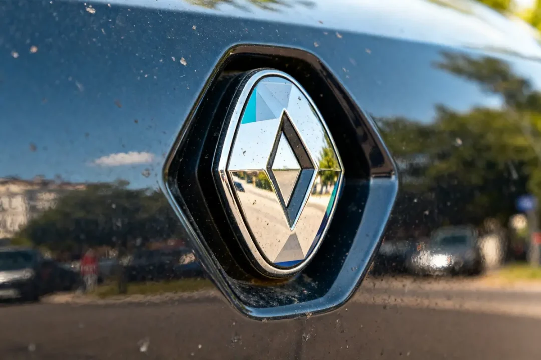 Gros plan sur un reflet dans le Renault logo d'une voiture noire en extérieur